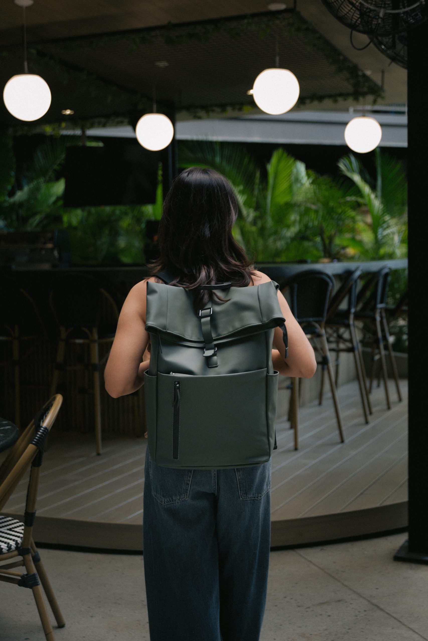 Persona llevando una mochila verde ARVA en una terraza