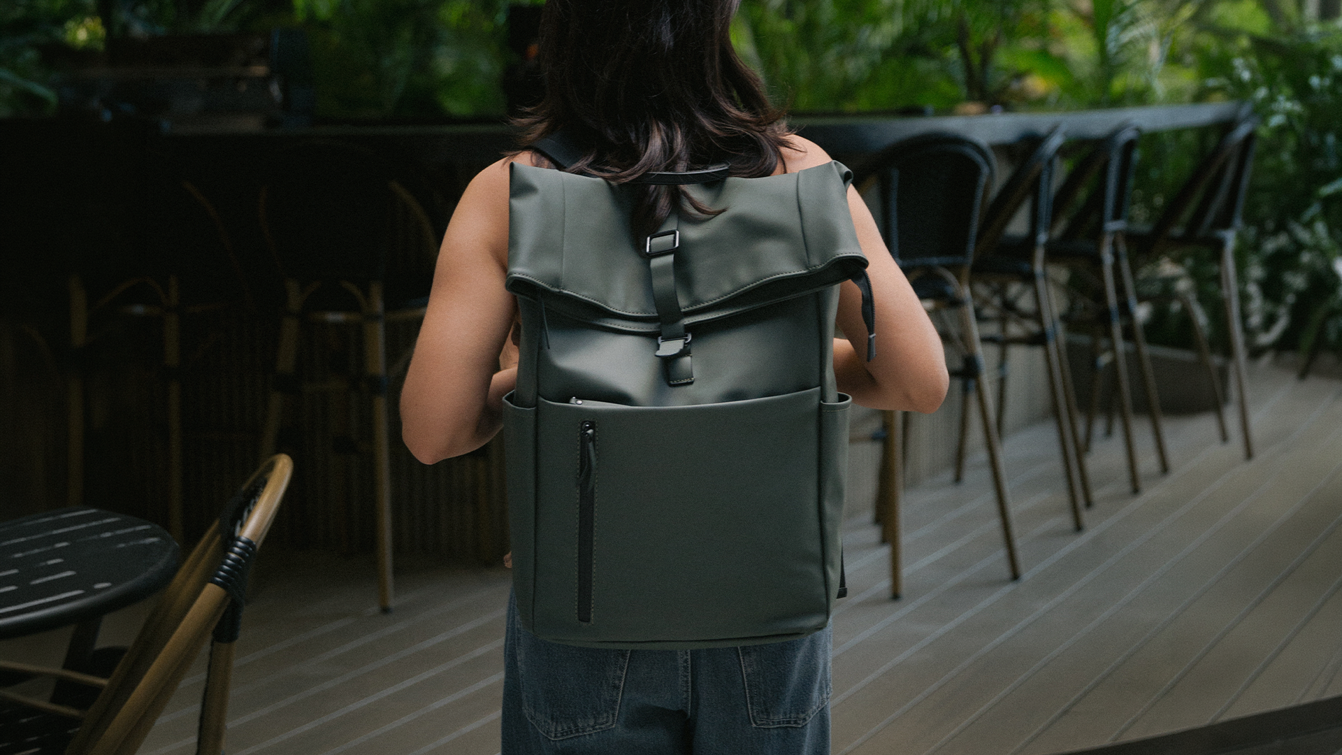 Persona llevando una mochila verde ARVA en una terraza